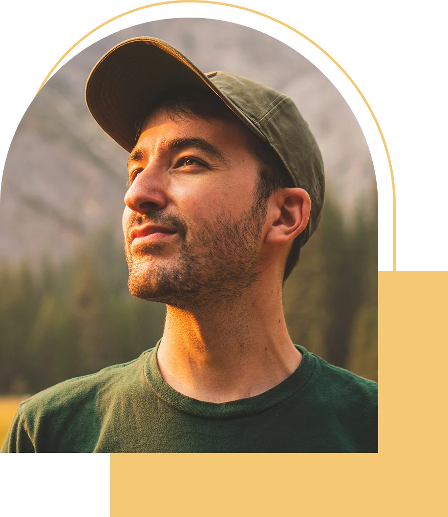 Man in cap looking into distance outdoors.